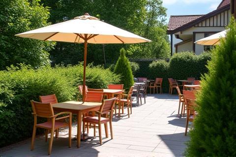 Pleasant outdoor patio seating area at Raststation Enzian, surrounded by greenery, perfect for a break